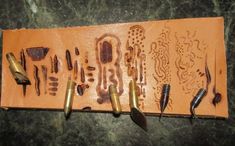 an assortment of tools are laid out on a leather case with holes and screws