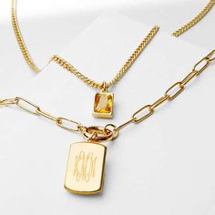 Instantly add a statement to your outfit with our monogrammed tag necklace, available in a gold-toned finish. This two-in-one, double-chain layered necklace features a faux citrin stone and a monogrammed tag pendant. Be sure to complete your look with a monogrammed bracelet and monogrammed earrings!Made of Brass14-inch short cable chain and an 18-inch long link chain with 2 inch extenderFaux citrine gemstone measures approximately 11mm x 6mmMonogrammed tag measures 19mm x 11mm Gift Monogram Initial Necklace In Tan, Yellow Gold Pendant Charm Necklaces With Monogram, Personalized Gold Rectangular Charm Necklace, Classic Tan Monogram Necklace, Yellow Gold Monogram Pendant Charm Necklace, Monogram Earrings, Double Chain, Citrine Stone, Citrine Gemstone