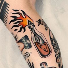 a person with tattoos on their legs and arm holding a bottle filled with something in it