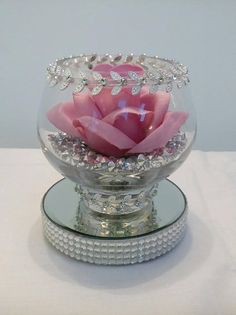 a glass bowl with a pink rose in it