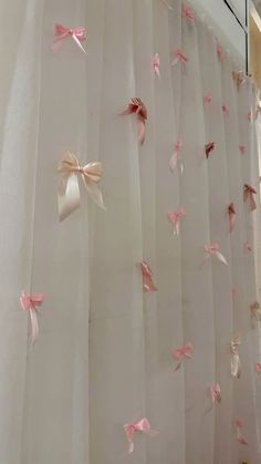 pink and white curtains with bows hanging from them