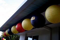 some paper lanterns hanging from the side of a house