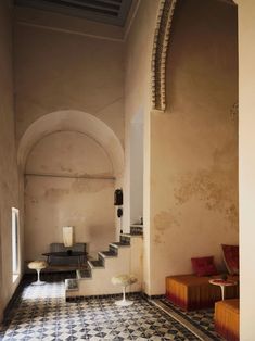 the interior of an old building with tiled flooring and stairs leading up to it