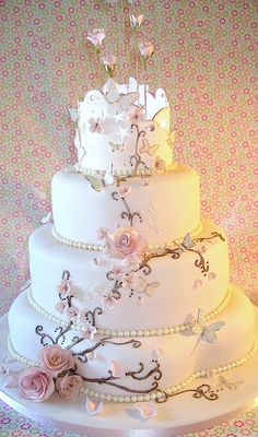 a white wedding cake with pink flowers and pearls