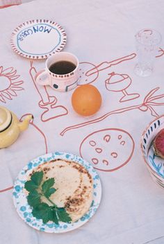 a table topped with plates and bowls filled with food next to an egg, cup of coffee