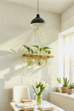 a table with some flowers and books on it in front of a wall mounted planter