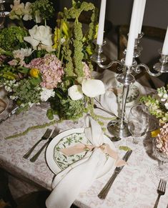 the table is set with flowers, candles and silverware for an elegant wedding reception