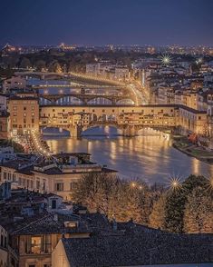 the city is lit up at night with its lights on and water running through it