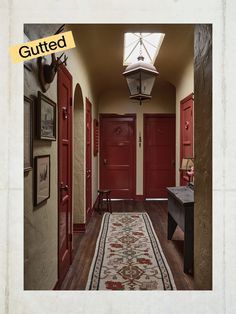 a hallway with two red doors and a rug on the floor