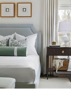 a bedroom with a bed, nightstand and two framed pictures on the wall above it