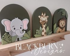 there are three wooden animals on the shelf next to each other, and one has an elephant