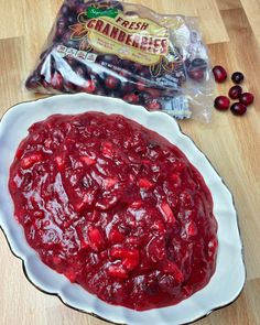 cranberry sauce in a white bowl next to bag of fresh cranberries