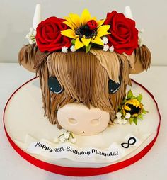 a birthday cake decorated with a cow's head and flowers