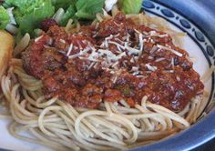 a plate with spaghetti, bread and lettuce on it