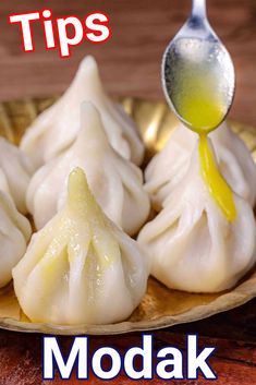 dumplings on a gold plate with a spoon in it and the title tips modak