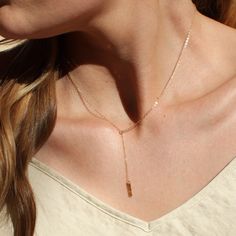 "Our dainty lariat necklace is stylish and minimalist. This dainty necklace is perfect with your favorite tee or your little black dress. A tiny bar adorns a silver or gold chain.  D E T A I L S *Dainty 12mm bar  *Hammered by hand  *2 inch drop  *Dainty link chain *100% 14kt gold-filled or sterling silver LENGTH *The standard length is normally 18\". *Model is wearing a 16\" in Photos. HOW TO PERSONALIZE *Select your choices from the drop down menu to create your custom design. ∙ EXTRA LOVE ∙ Handcrafted just for you in sunny Arizona by a team of talented women. All of our jewelry comes gift packaged! We are happy to leave a note if this is a special gift, just let us know in the message box at checkout. PRODUCTION ∙ TIMES All items are made to order. Please check the estimated delivery in Dainty Adjustable Lariat Necklace, Dainty Lariat Necklace With Adjustable Long Drop, Dainty Long Drop Lariat Necklace With Adjustable Length, Minimalist Lariat Jewelry For Everyday, Delicate Rose Gold Lariat Necklace Gift, Delicate Rose Gold Lariat Necklace, Everyday Minimalist Lariat Jewelry, Adjustable Dainty Lariat Necklace, Adjustable Rose Gold Dainty Lariat Necklace