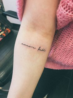 a woman's arm with a small tattoo that reads, i am not here