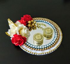 there is a plate with some flowers on it and two small gold discs next to each other