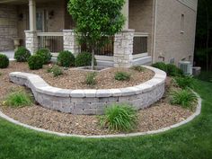 a stone retaining wall in front of a house