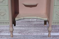 a pink and white table with drawers on it