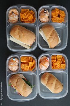 six plastic containers filled with sandwiches and fruit