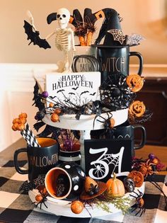 a table topped with black and white cups filled with halloween decorations