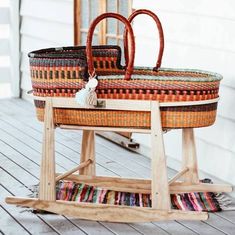 a basket sitting on top of a wooden stand next to a planter and potted plant