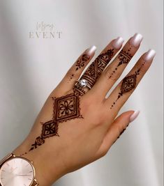 a woman's hand with henna on it and a watch around her wrist