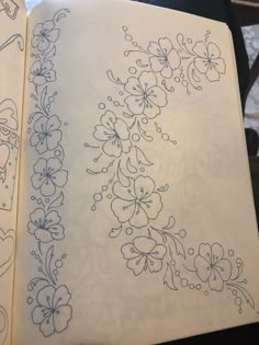 an open notebook with some drawings on it and one is drawn in blue ink, the other has black ink