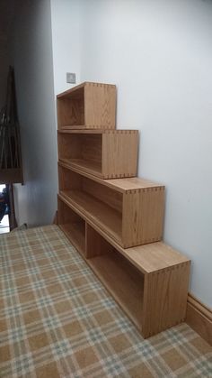 a set of wooden shelves sitting on top of a carpeted floor