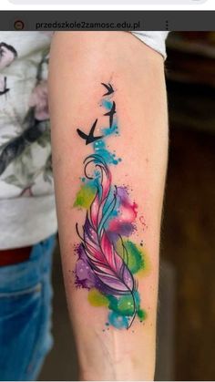 a colorful feather tattoo on the arm