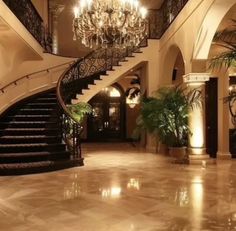 an elegant foyer with chandelier and marble floors