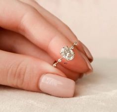 a woman's hand with a gold ring on it and a diamond in the middle