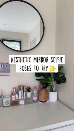 a mirror sitting on top of a white counter next to a potted green plant