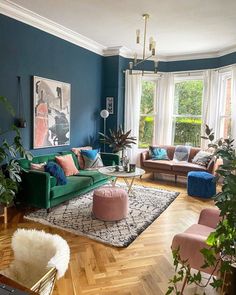 a living room filled with lots of furniture and plants on top of hard wood flooring