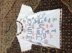 a white t - shirt with the words junior jewels written in different languages on it