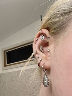 a close up of a person with ear piercings on their ears and behind the ear