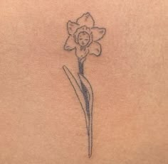 a small flower tattoo on the back of a woman's stomach