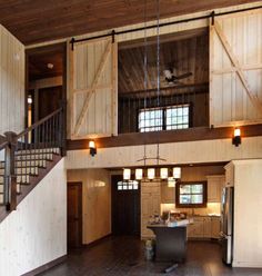 a large open floor plan with wood paneling and wooden stairs leading up to the second story