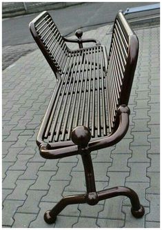 an old metal bench sitting on top of a sidewalk