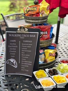 a table topped with different types of food and drinks next to a chalkboard sign