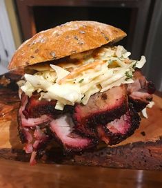 a sandwich with meat and cole slaw on a cutting board