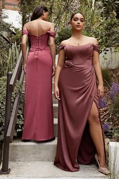 two women in long dresses standing on the steps outside with their backs to each other