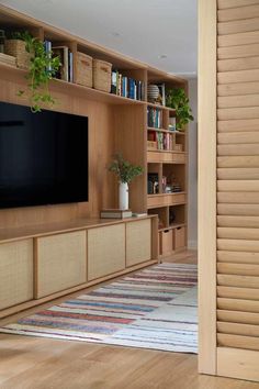 a living room filled with furniture and a flat screen tv on top of a wooden entertainment center