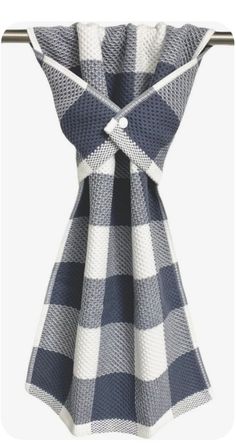 a black and white checkered dress hanging on a clothes rack with an attached tie