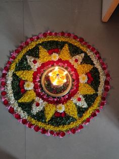 a lit candle is surrounded by flowers and petals