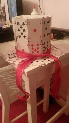 a stack of playing cards sitting on top of a table with a red ribbon around it