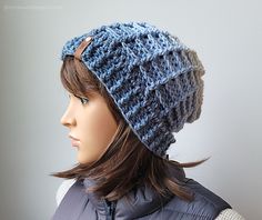 a mannequin head wearing a blue knitted hat with a button on it