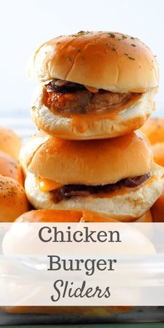 chicken burger sliders stacked on top of each other in front of some buns