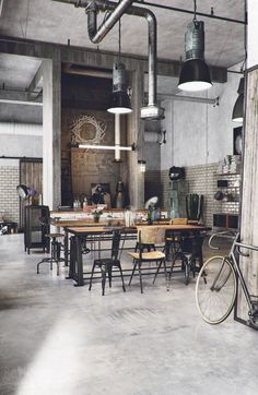 an industrial style kitchen with tables and chairs